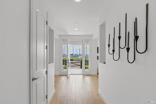 corridor with baseboards, recessed lighting, and light wood-style floors