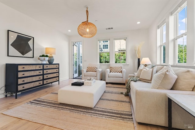 living area with baseboards, wood finished floors, visible vents, and recessed lighting