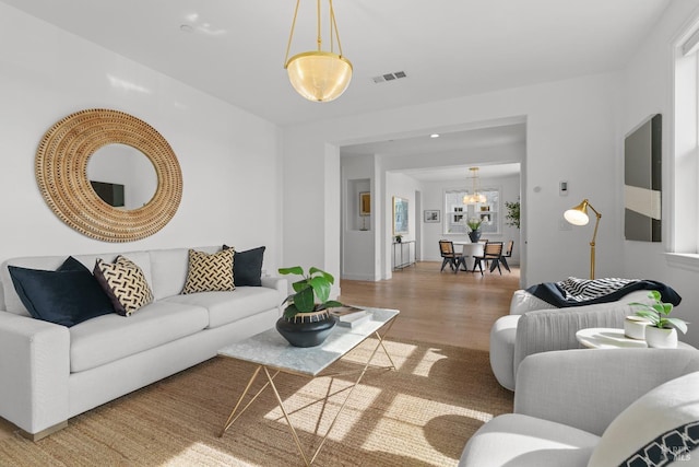 living area featuring visible vents and light wood-style floors