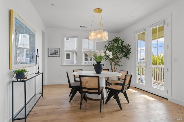 dining area featuring light wood-type flooring, french doors, visible vents, and baseboards