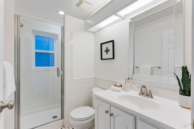 bathroom featuring vanity, a shower with shower door, tile walls, and toilet