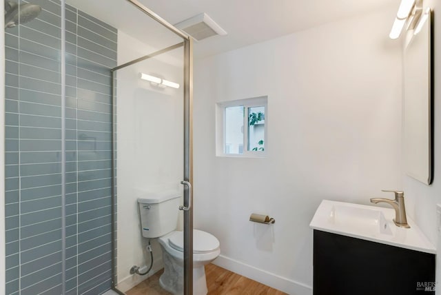 bathroom featuring vanity, an enclosed shower, hardwood / wood-style floors, and toilet