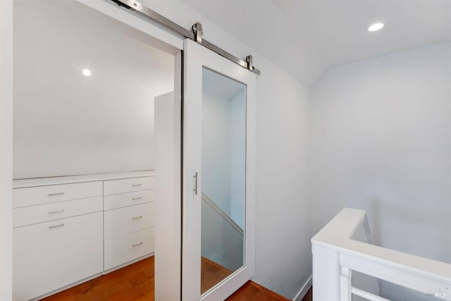 bathroom featuring hardwood / wood-style flooring and vaulted ceiling