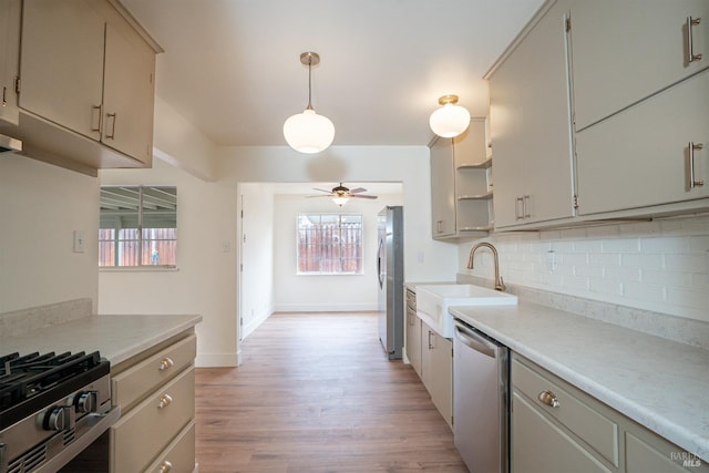 kitchen featuring pendant lighting, sink, ceiling fan, stainless steel appliances, and tasteful backsplash