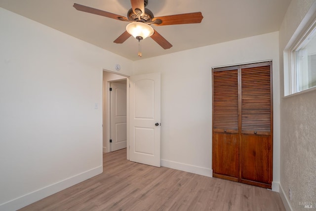 unfurnished bedroom featuring ceiling fan, light wood-type flooring, and a closet