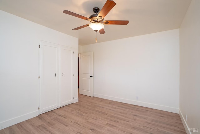 unfurnished bedroom featuring light hardwood / wood-style floors, a closet, and ceiling fan