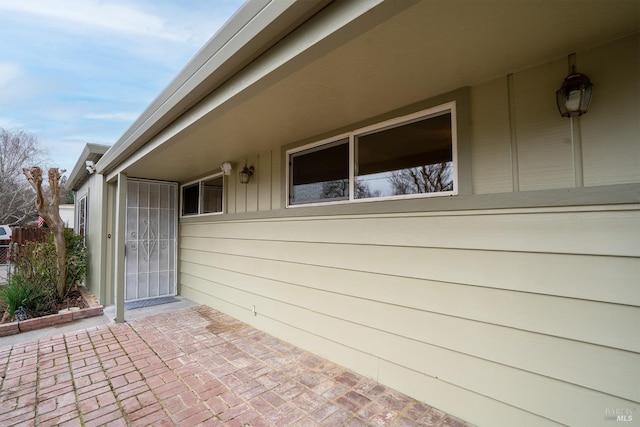 view of exterior entry with a patio area