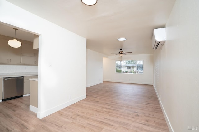 unfurnished living room with a wall unit AC, ceiling fan, and light wood-type flooring