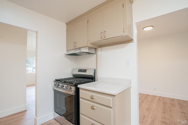 kitchen with stainless steel range with gas stovetop, light wood-type flooring, and cream cabinetry