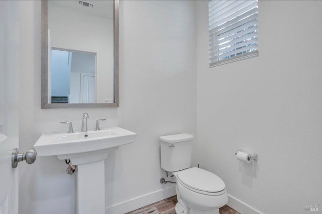 bathroom with hardwood / wood-style floors and toilet