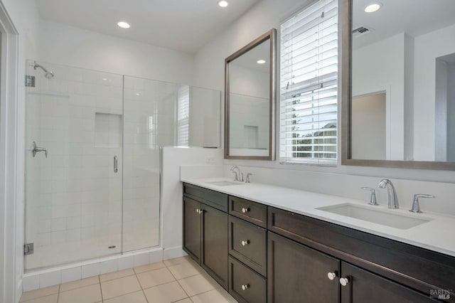 bathroom with tile patterned flooring, vanity, and a shower with shower door