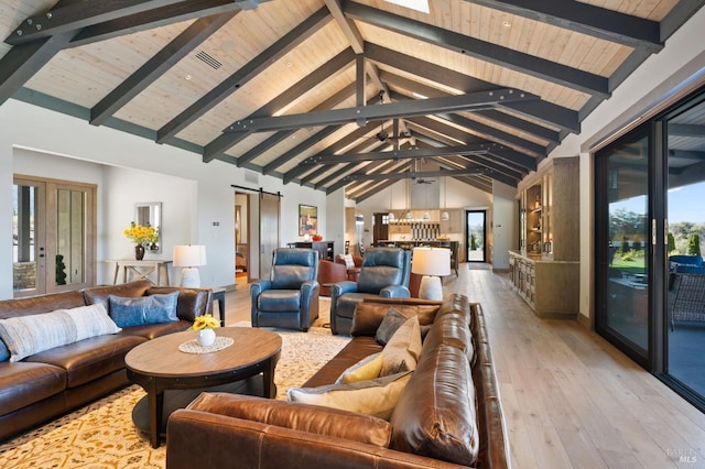 living room with a healthy amount of sunlight, high vaulted ceiling, a barn door, and beamed ceiling