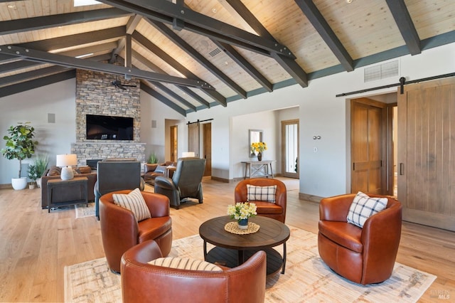 living room featuring light hardwood / wood-style flooring, high vaulted ceiling, a barn door, and beamed ceiling