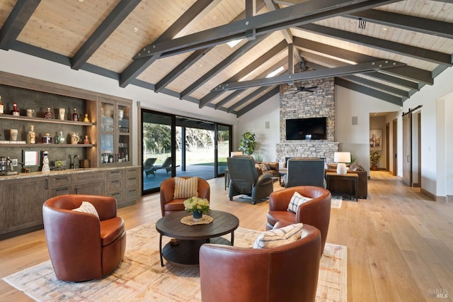 living room with a barn door, beam ceiling, and light wood-type flooring