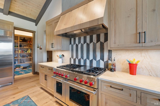 kitchen with light brown cabinetry, vaulted ceiling with beams, high quality appliances, custom range hood, and backsplash