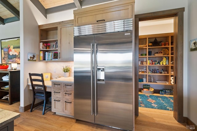 kitchen with decorative backsplash, stainless steel built in fridge, light hardwood / wood-style flooring, and light brown cabinets