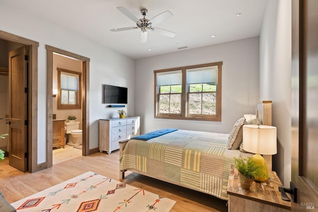 bedroom with ceiling fan, ensuite bathroom, and light hardwood / wood-style floors