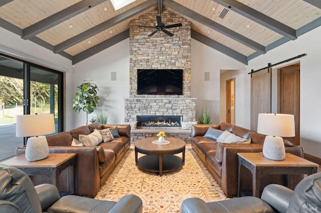 living room featuring beamed ceiling, a barn door, a fireplace, and high vaulted ceiling