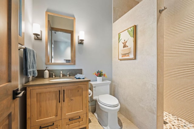 bathroom with tile patterned flooring, vanity, walk in shower, and toilet