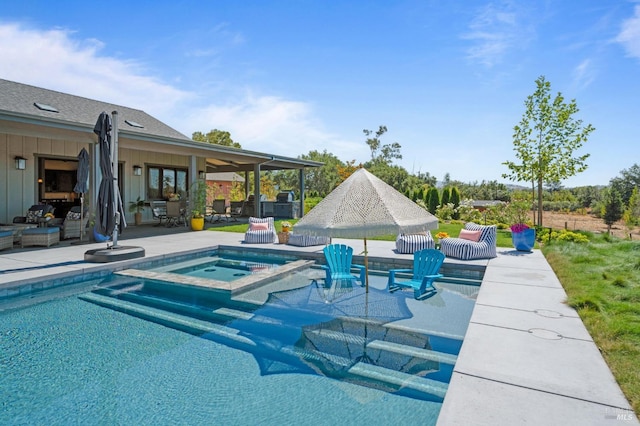 view of pool featuring a patio area and an in ground hot tub