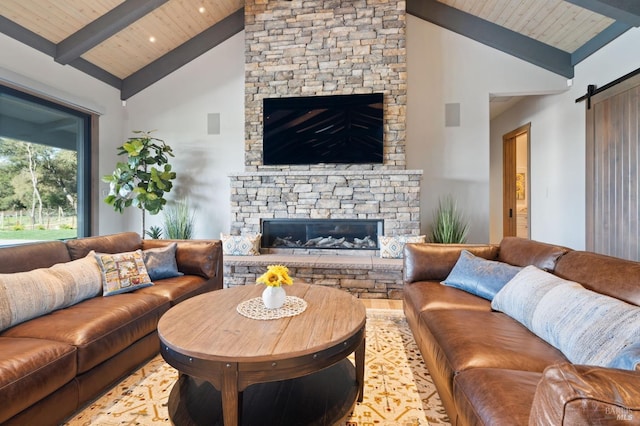 living room featuring a stone fireplace, beam ceiling, wood ceiling, high vaulted ceiling, and a barn door