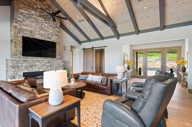 living room featuring high vaulted ceiling, a fireplace, wooden ceiling, a barn door, and beamed ceiling