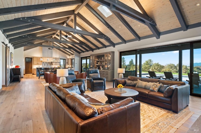 living room with high vaulted ceiling, beamed ceiling, a barn door, wooden ceiling, and light hardwood / wood-style flooring