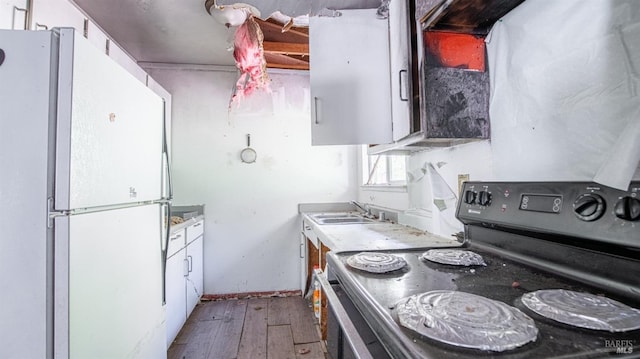 kitchen with hardwood / wood-style floors, white cabinetry, sink, white refrigerator, and black electric range