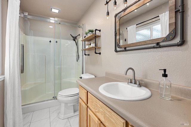 bathroom with vanity, toilet, and a shower with door