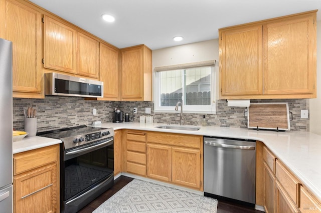 kitchen featuring stainless steel appliances, sink, decorative backsplash, and light wood-type flooring