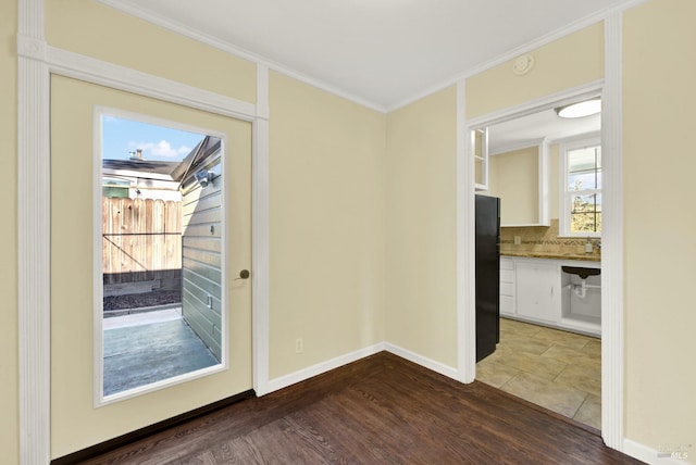 doorway with ornamental molding and hardwood / wood-style floors