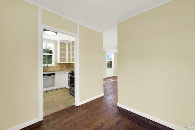 interior space with hardwood / wood-style flooring, ornamental molding, and a healthy amount of sunlight