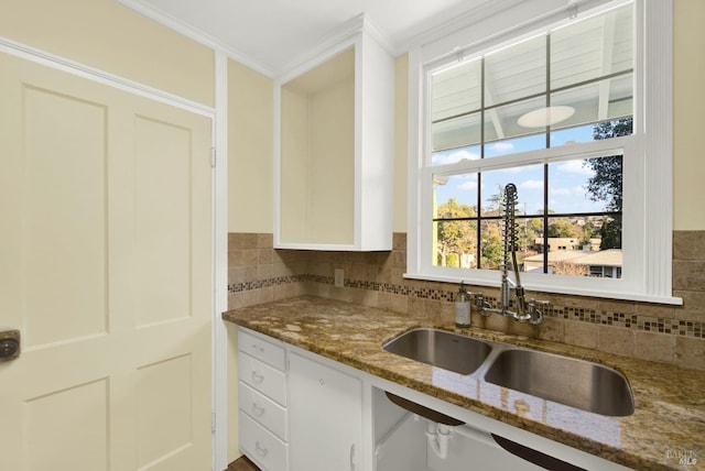 kitchen featuring white cabinetry, stone countertops, sink, and crown molding