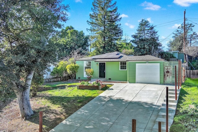 ranch-style house with a garage, a front yard, and solar panels