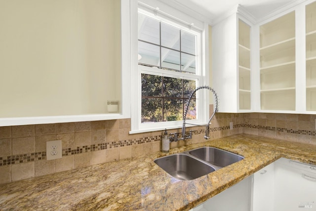 kitchen featuring sink, crown molding, light stone countertops, and backsplash