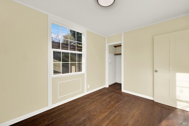 unfurnished bedroom with dark wood-type flooring and a closet