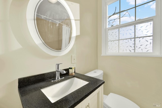 bathroom with vanity, toilet, and walk in shower