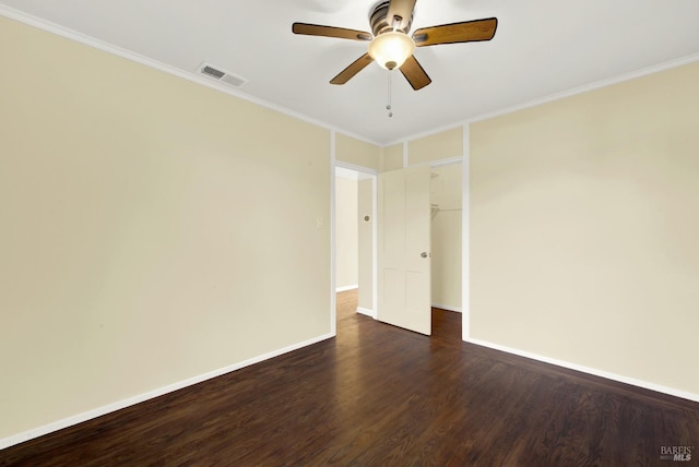 empty room featuring crown molding, dark wood-type flooring, and ceiling fan