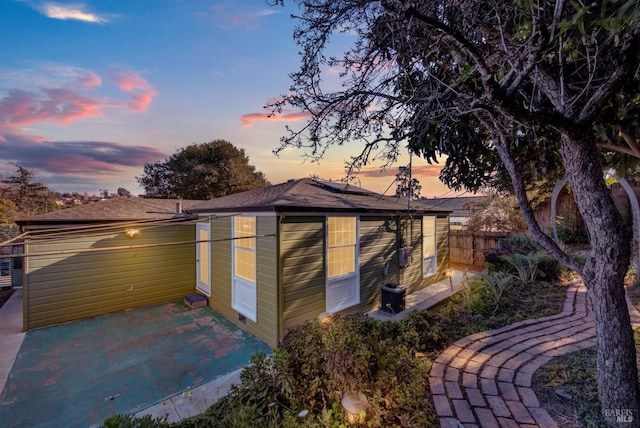 property exterior at dusk featuring a patio