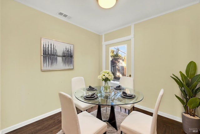 dining space featuring crown molding and dark hardwood / wood-style floors