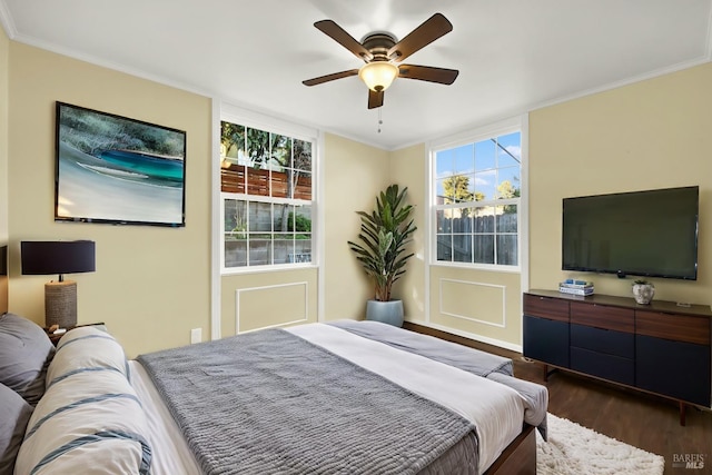 bedroom featuring dark wood-type flooring, ceiling fan, and ornamental molding