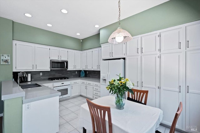 kitchen featuring sink, white appliances, white cabinetry, decorative backsplash, and decorative light fixtures