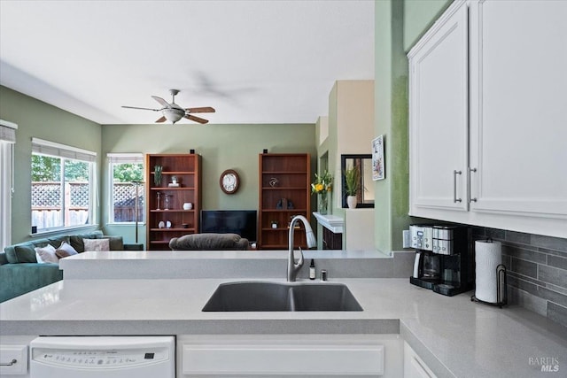 kitchen featuring sink, ceiling fan, white cabinetry, backsplash, and white dishwasher