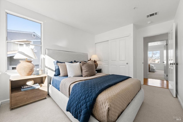 bedroom with light colored carpet and a closet