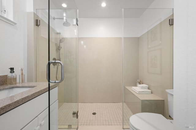 bathroom with tile patterned floors, vanity, toilet, and an enclosed shower