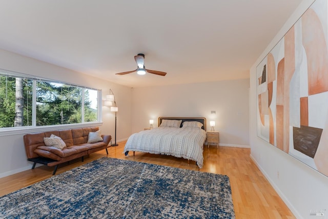 bedroom featuring baseboards, ceiling fan, and light wood-style floors