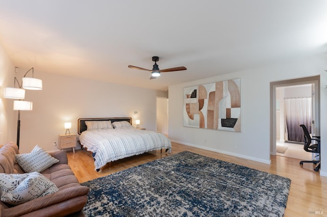 bedroom featuring baseboards, a ceiling fan, and light wood-style flooring