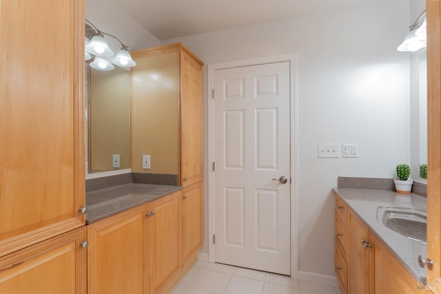 bathroom with tile patterned floors, baseboards, and vanity