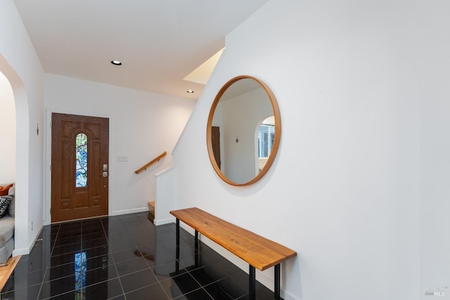entrance foyer featuring stairway, baseboards, arched walkways, recessed lighting, and tile patterned flooring