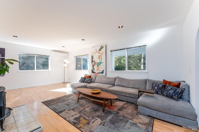 living room with wood-type flooring and a wall unit AC